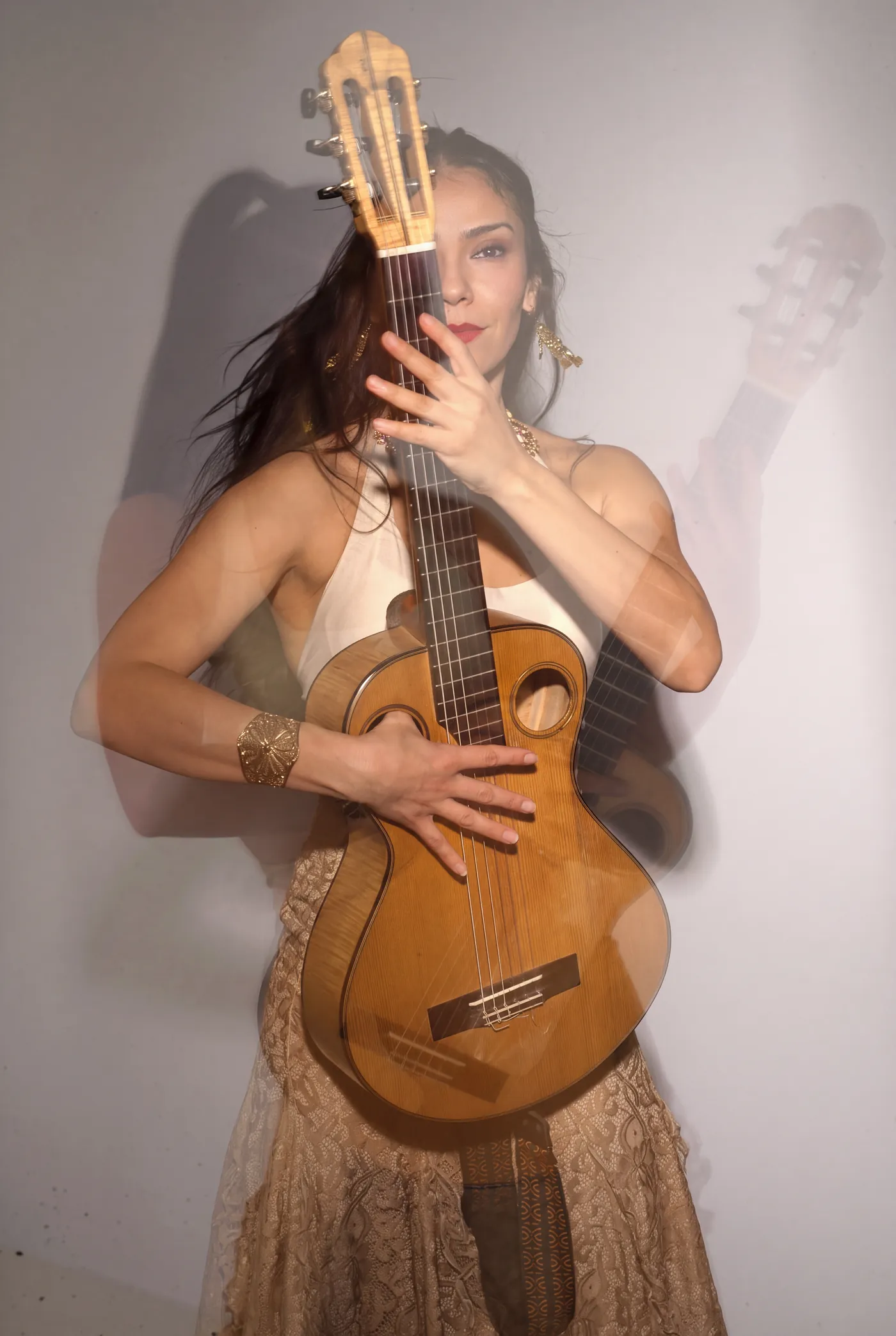 Mamselle Ruiz en double exposition, serrant sa guitare contre elle