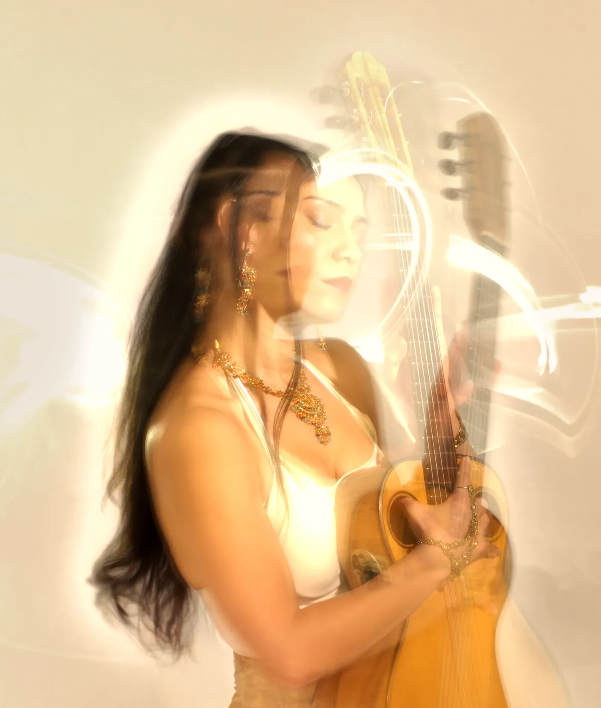Mamselle Ruiz, les yeux fermés, serre sa guitare dans des traînées de lumière blanche