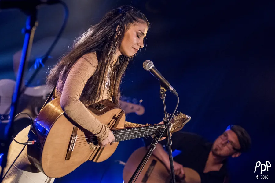 Mamselle Ruiz chante à la guitare sous une lumière bleue