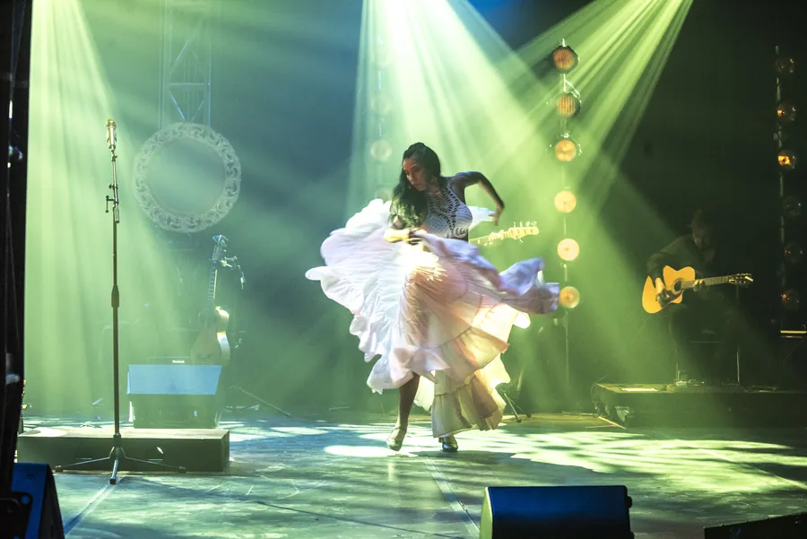 Mamselle Ruiz danse, sa robe blanche tournoie dans la lumière verte